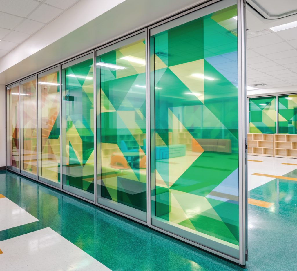 Geometric coloured window film across a glass classroom wall
