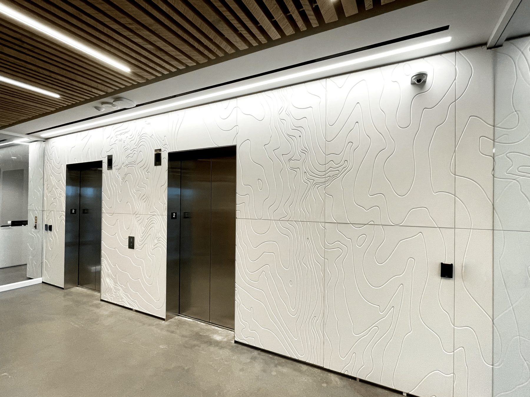 White elevator lobby wall carved with a topographic contour pattern